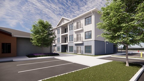 A modern building with a parking lot in front.