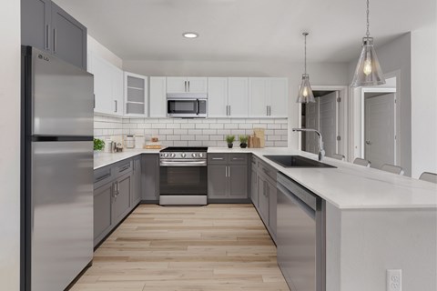 A modern kitchen with a refrigerator, oven, and microwave.