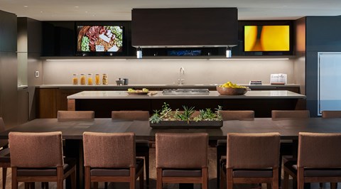 A modern kitchen with brown chairs and a wooden table.