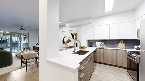 A modern kitchen with a white countertop and wooden cabinets.