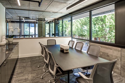 A conference room with a long table and chairs.