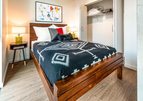 A bedroom with a bed, nightstand, and lamp.