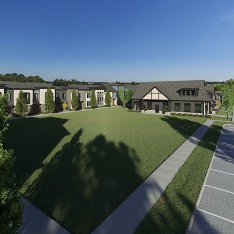 A row of houses with a large lawn in front.
