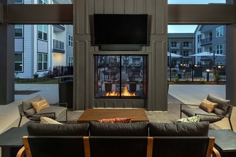 A modern living room with a fireplace and a television mounted above it.