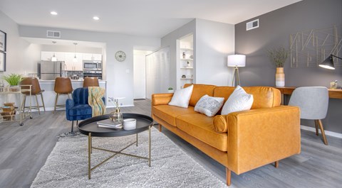 A modern living room with a yellow sofa and a coffee table.