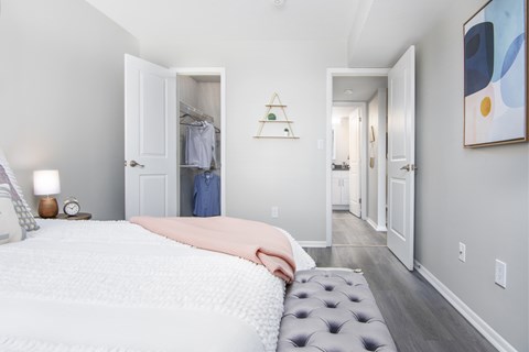 A bedroom with a large bed and a painting on the wall.