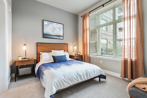 A bedroom with a large bed and a painting on the wall.