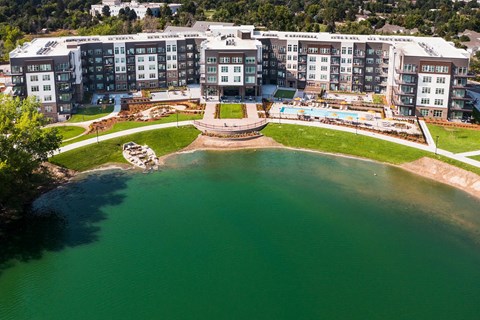 A large building complex with a pool in front.