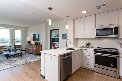 A modern kitchen with white cabinets and stainless steel appliances.