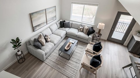 A living room with a grey sofa, a coffee table, and a painting on the wall.