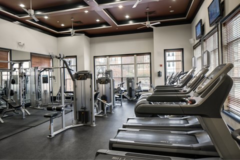 A gym with treadmills, weights, and exercise equipment.