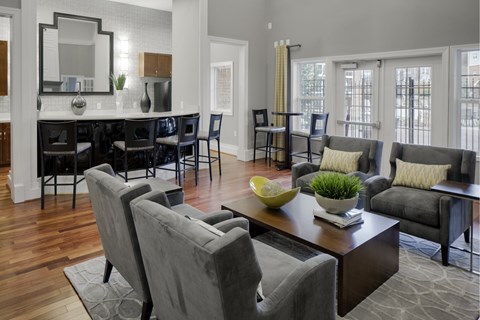 A modern living room with grey chairs and a wooden floor.