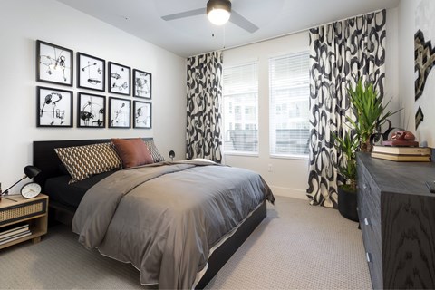A bedroom with a large bed and a ceiling fan.