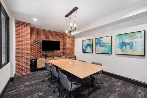 A conference room with a long table and chairs.