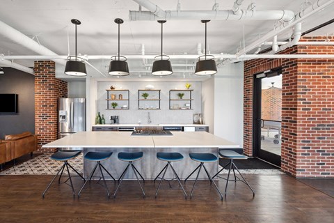 A modern kitchen with a white table and blue chairs.