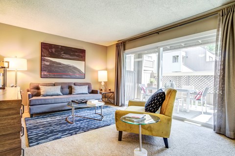 A living room with a yellow chair and a grey couch.