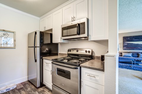 A kitchen with white cabinets and stainless steel appliances.