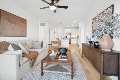 A living room with a white couch and a wooden coffee table.