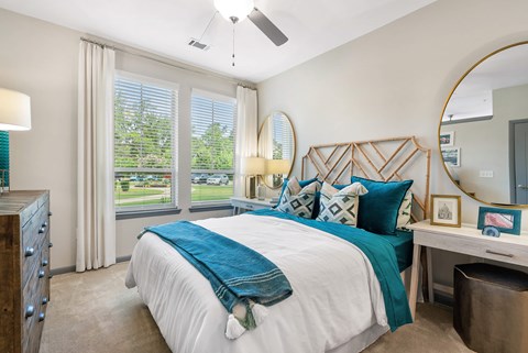 A bedroom with a large bed and a ceiling fan.