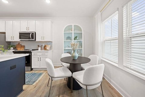 A kitchen with a table and chairs in the middle.