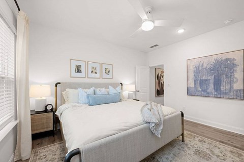 A bedroom with a large bed and a painting on the wall.