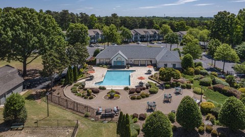 A bird's eye view of a community with a swimming pool and a fenced area with chairs.