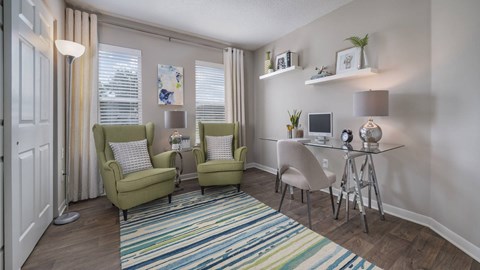 A living room with a striped rug and a green chair.
