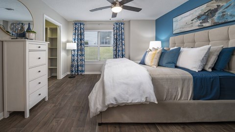 A bedroom with a large bed and a dresser.