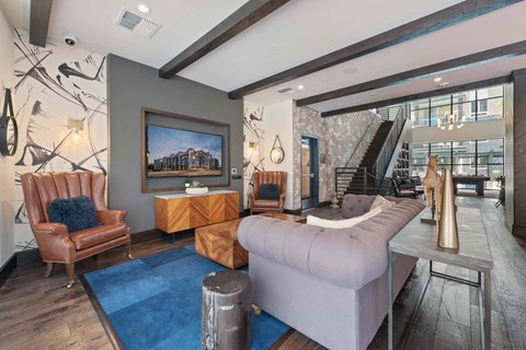 A living room with a brown leather chair and a grey sofa.