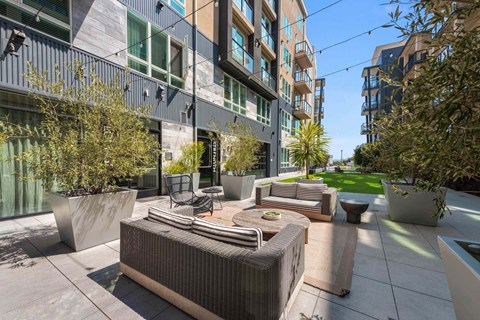 A modern outdoor seating area with a hot tub and chairs.