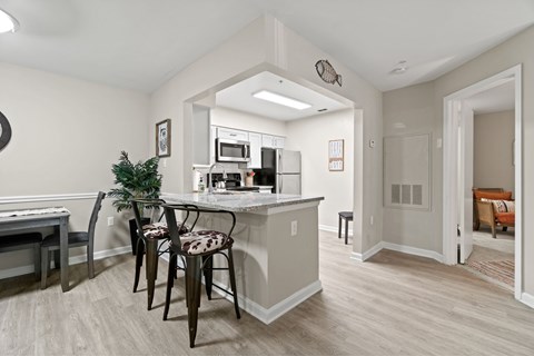 A kitchen with a white counter top and a white fridge.