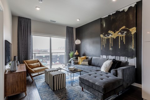 A living room with a large black and gold painting on the wall.