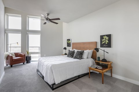 A bedroom with a large bed and a ceiling fan.