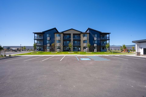 A large parking lot in front of a multi-story building.