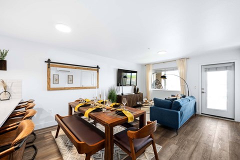 A dining room with a wooden table set for a meal.