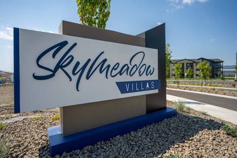 A sign for Skyhaven Villas in front of a building.