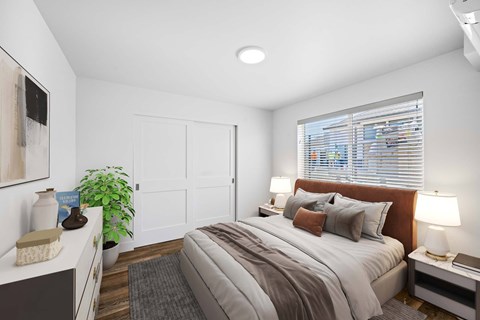 A bedroom with a large bed and a window with blinds.