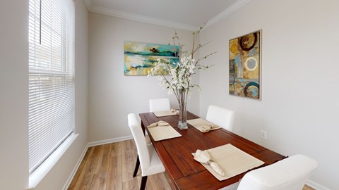 A dining room with a wooden table and white chairs.