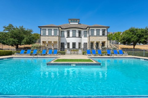A large house with a pool in front.