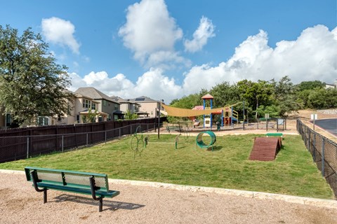 A playground with a green bench and a red slide.