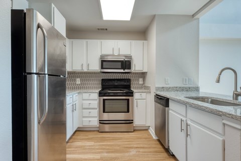 A kitchen with white cabinets and stainless steel appliances.