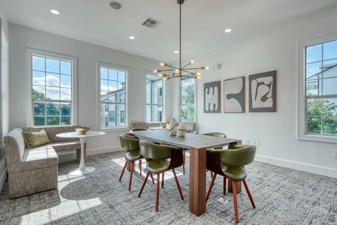A dining room with a round table and chairs.