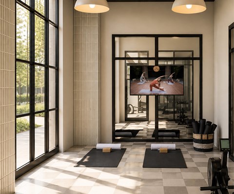 A yoga studio with a large screen showing a yoga class.