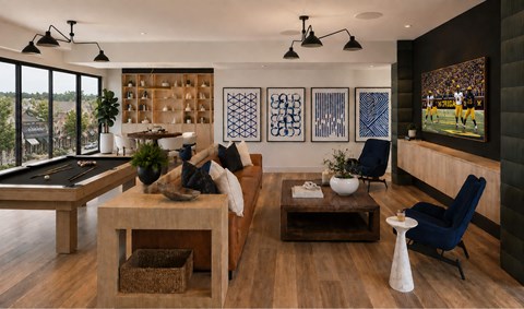 A modern living room with a pool table and a view of the city.