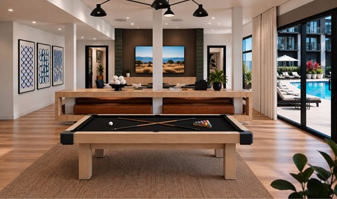 A pool table is in the middle of a room with a billiard table in the background.