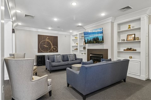 A living room with a grey couch and a fireplace.