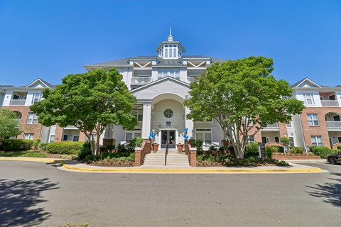 A large building with a tower and a gate in front.