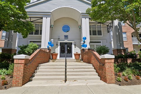 A house entrance with a brick wall and steps.