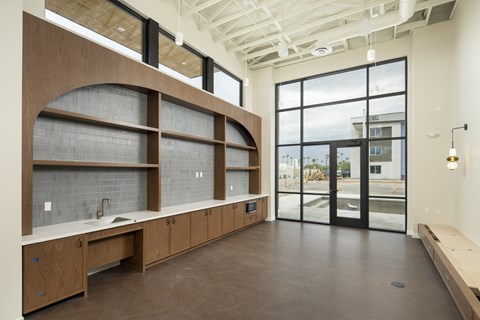 A modern kitchen with wooden cabinets and a large window.