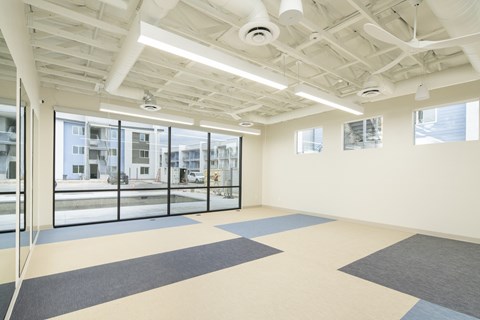 A room with a white ceiling and a large window overlooking a building.